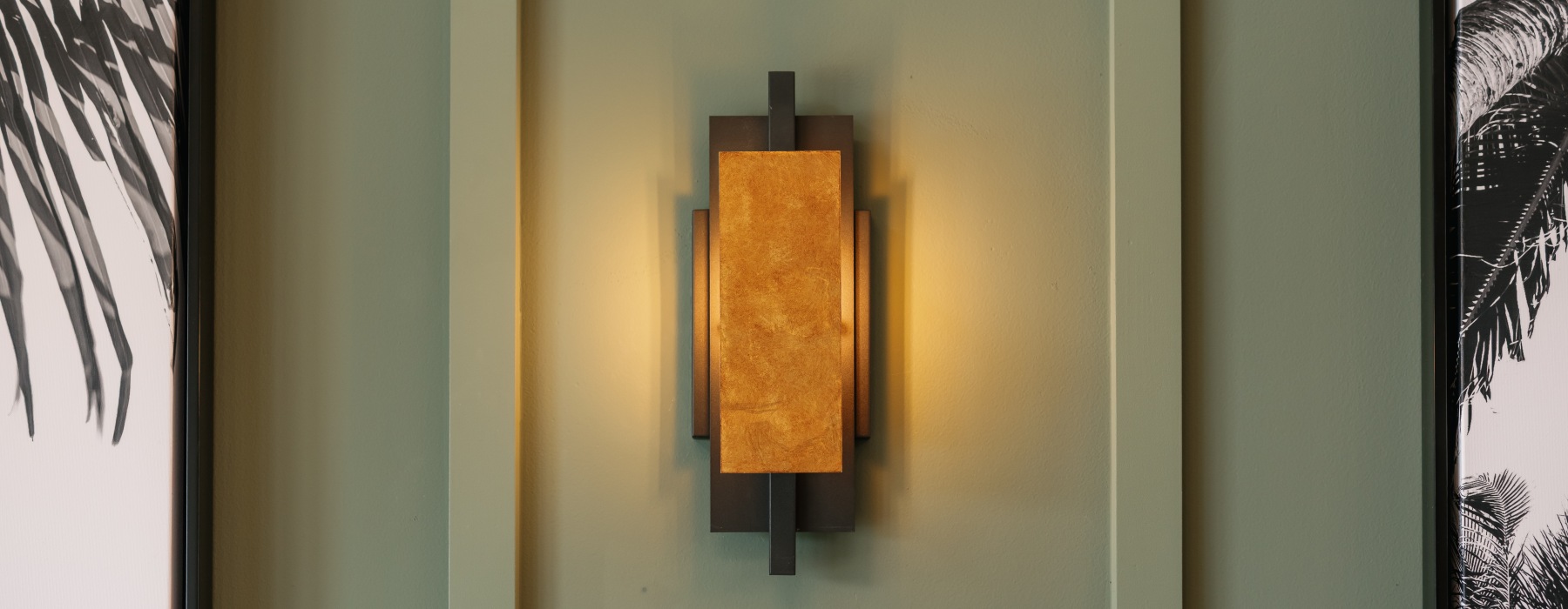 light on wall surrounded by coastal art