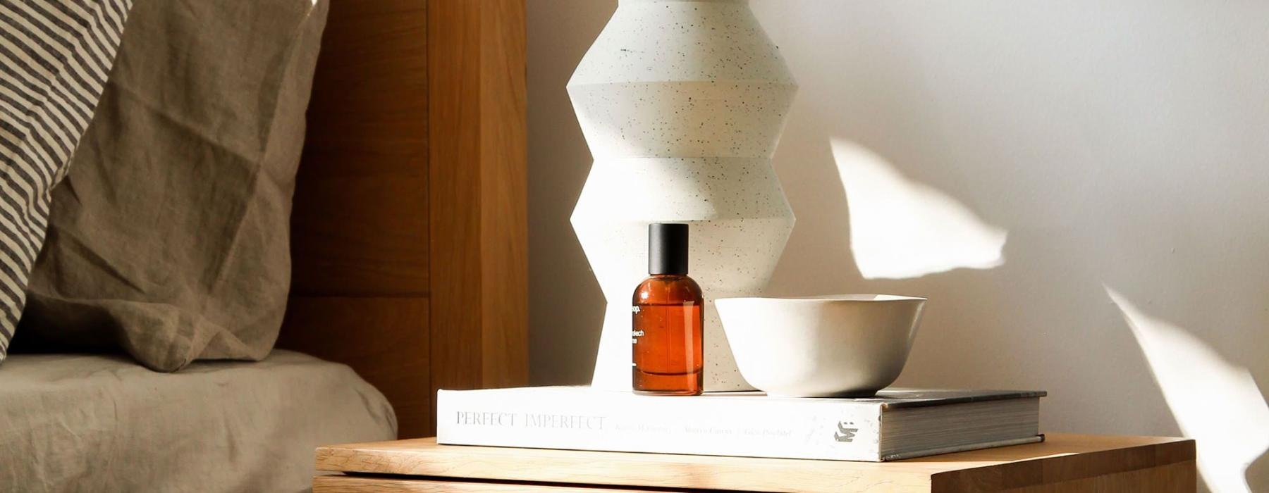 a vase with cotton stems on a bedside table