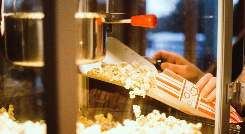 a person pouring popcorn into a container